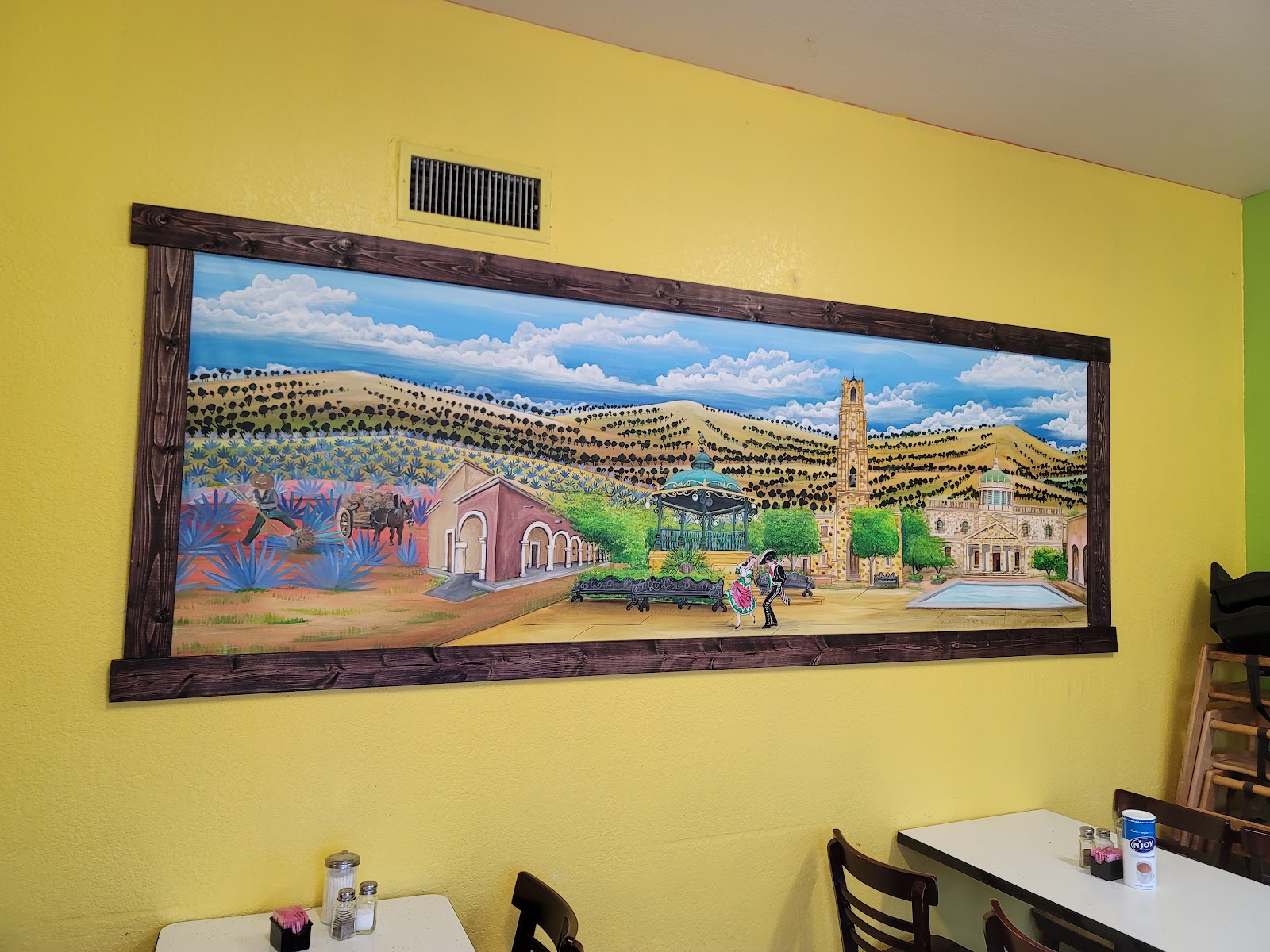 Mural of a Mexican village painted on the dining room wall